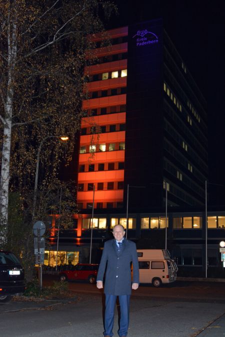 Landrat Christoph Rüther vor dem in Orange angeleutetem Kreishaus zum Gedenktag "Nein - zur Gewalt gegen Frauen!"